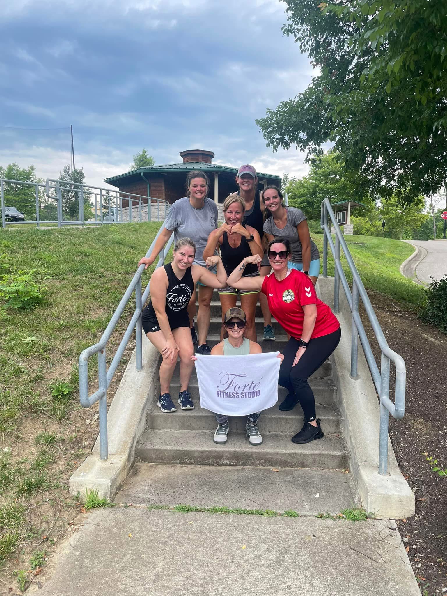 Group on park stairs with Forté banner