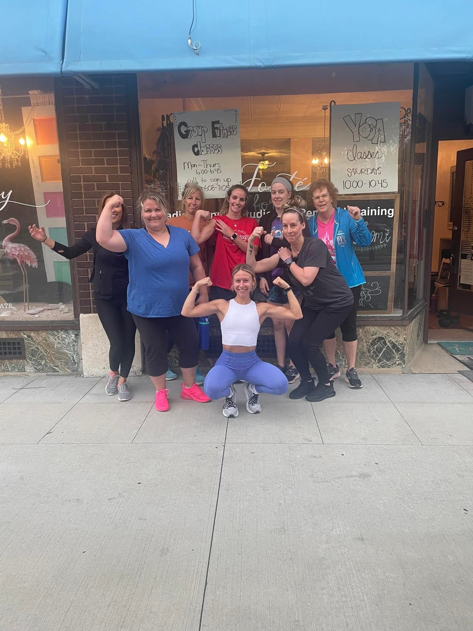 Women flexing outside storefront